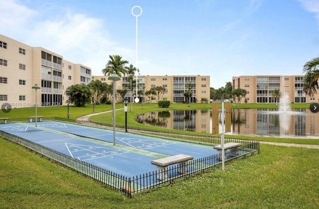 view of property's community featuring a lawn and a water view