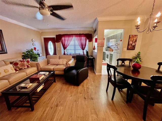 living room featuring ornamental molding, light hardwood / wood-style flooring, a textured ceiling, and ceiling fan with notable chandelier