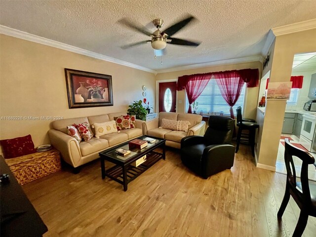 living room with ornamental molding, a textured ceiling, hardwood / wood-style flooring, and ceiling fan