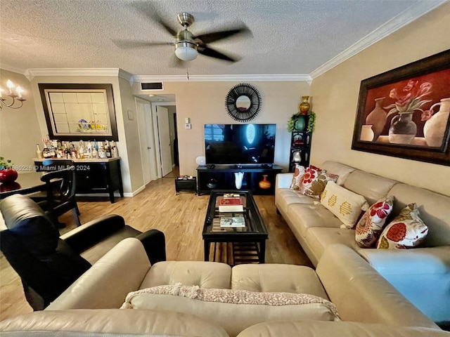 living room featuring ceiling fan, crown molding, wood-type flooring, and a textured ceiling