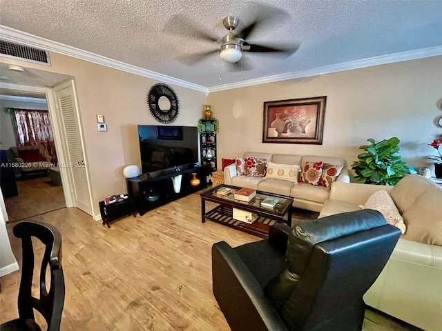 living room featuring hardwood / wood-style floors, crown molding, a textured ceiling, and ceiling fan