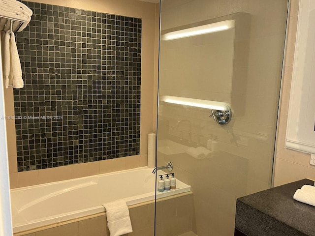 bathroom featuring shower with separate bathtub