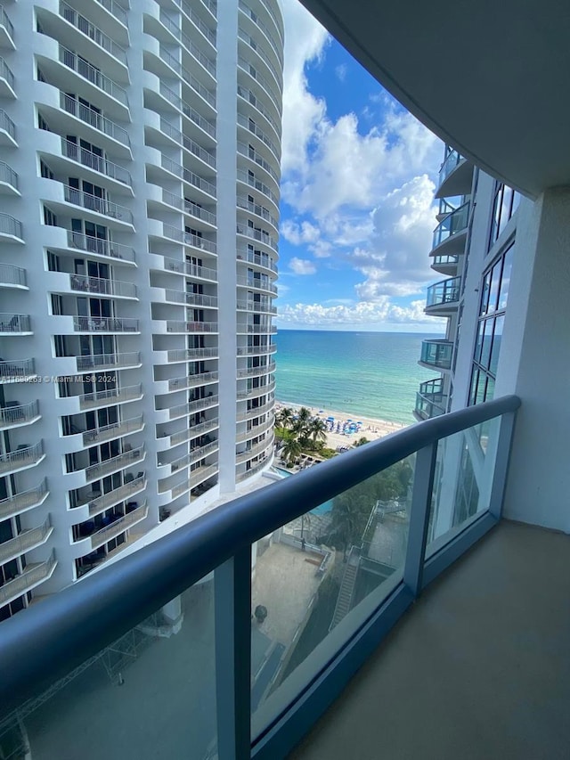 balcony featuring a water view and a view of the beach