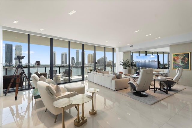 living room with light tile patterned floors, a wall of windows, a wealth of natural light, and a water view