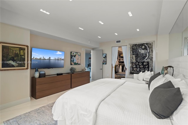 tiled bedroom with a walk in closet