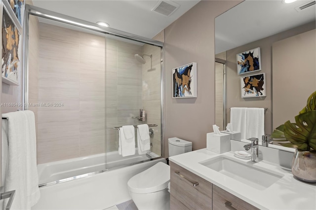 full bathroom with vanity, toilet, and bath / shower combo with glass door