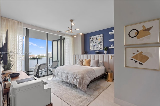 bedroom featuring access to exterior, a water view, and a chandelier