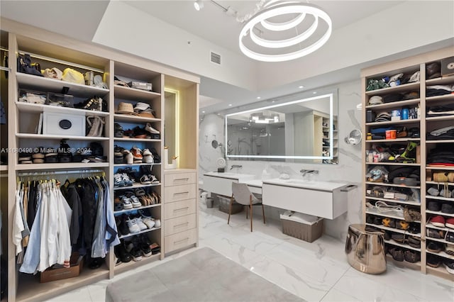 spacious closet with a raised ceiling and sink