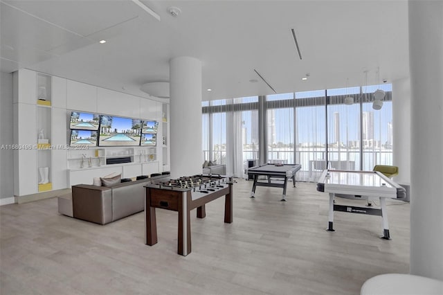 recreation room featuring light hardwood / wood-style floors and a wall of windows