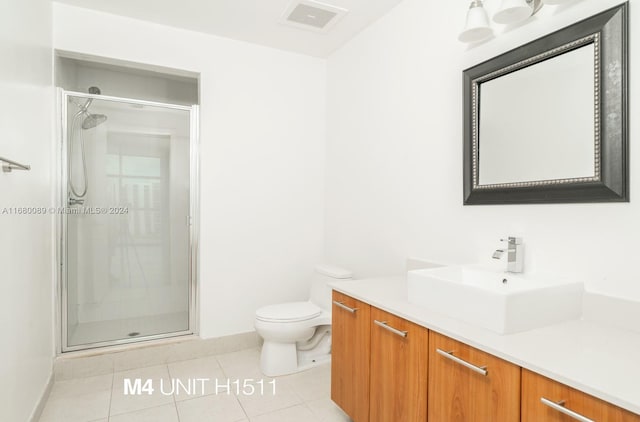 bathroom featuring vanity, a shower with shower door, toilet, and tile patterned flooring