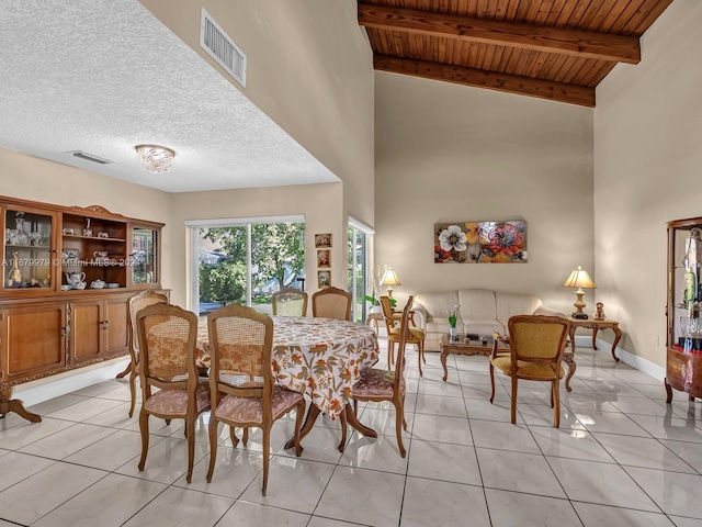 dining space featuring beam ceiling, light tile patterned flooring, high vaulted ceiling, and wooden ceiling