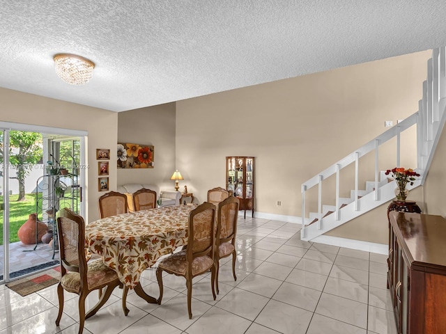 tiled dining space featuring a textured ceiling