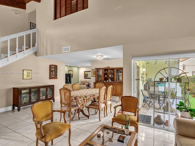 living room with a towering ceiling and light tile patterned floors