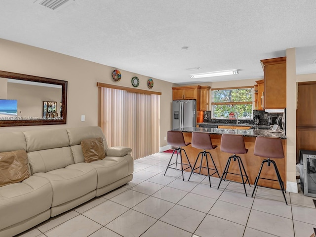 tiled living room featuring a textured ceiling and sink