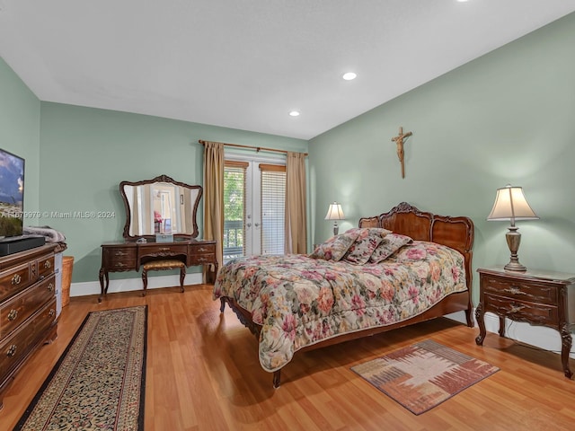 bedroom featuring access to exterior and light wood-type flooring