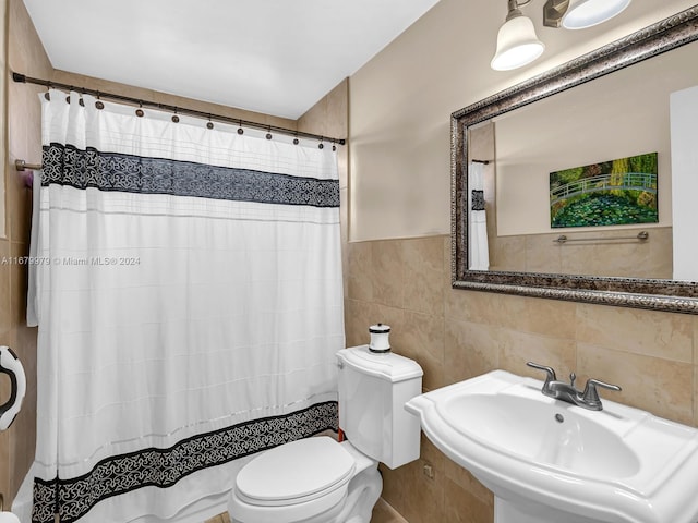 bathroom with tile walls, sink, toilet, and walk in shower