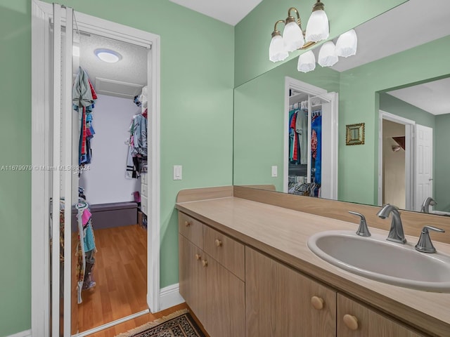 bathroom with vanity, hardwood / wood-style floors, and a chandelier