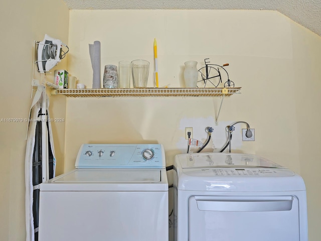 washroom with washing machine and dryer and a textured ceiling