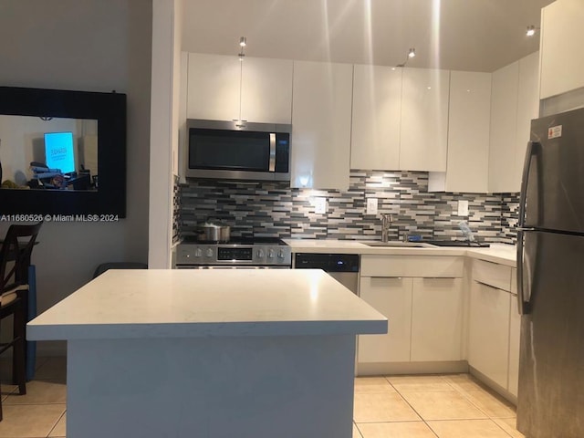 kitchen featuring backsplash, appliances with stainless steel finishes, and white cabinetry