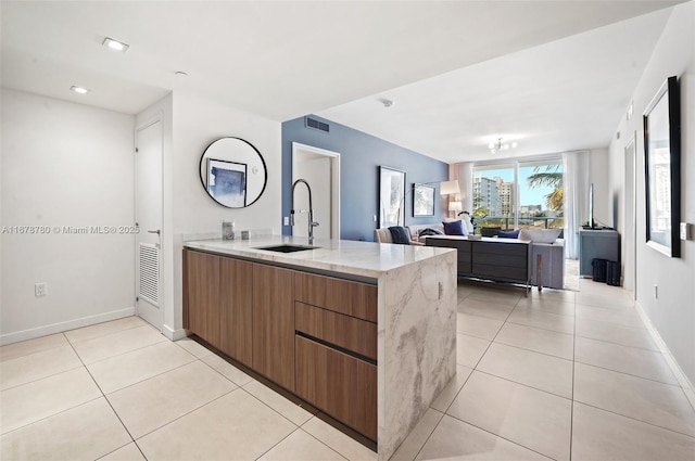 401 N Birch Rd Unit 505, Fort Lauderdale, FL 33304 - kitchen featuring a sink, baseboards, light stone countertops, light tile patterned floors, and modern cabinets