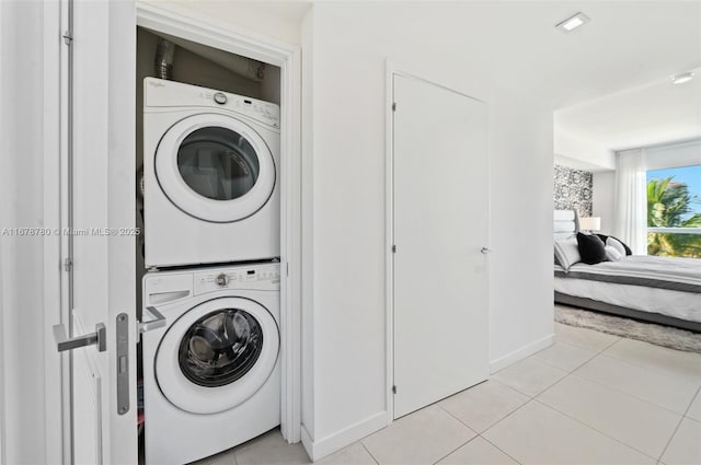401 N Birch Rd Unit 505, Fort Lauderdale, FL 33304 - washroom featuring stacked washer and clothes dryer, light tile patterned floors, and baseboards