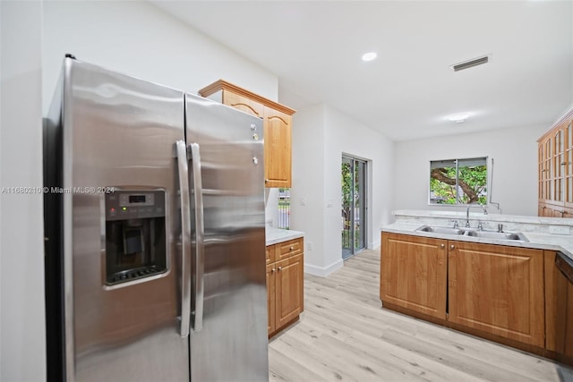 kitchen with sink, stainless steel fridge with ice dispenser, and light wood-type flooring