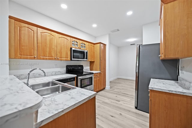 kitchen featuring appliances with stainless steel finishes, light hardwood / wood-style flooring, and sink