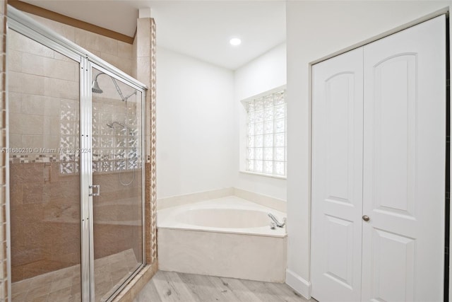 bathroom featuring independent shower and bath and hardwood / wood-style floors