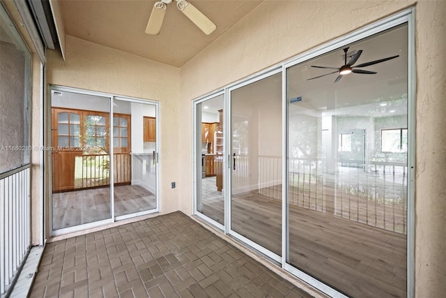 unfurnished sunroom featuring ceiling fan