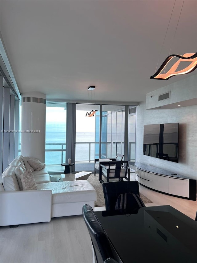 living area with wood finished floors, expansive windows, and visible vents