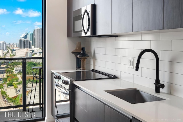 kitchen featuring stainless steel appliances, tasteful backsplash, sink, and gray cabinets