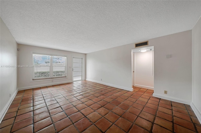 tiled spare room with a textured ceiling