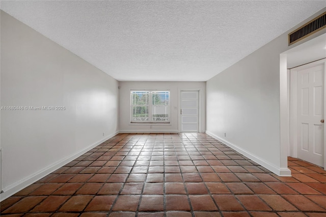 unfurnished room with a textured ceiling