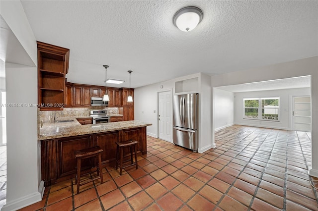 kitchen featuring stainless steel appliances, kitchen peninsula, decorative light fixtures, a kitchen bar, and decorative backsplash