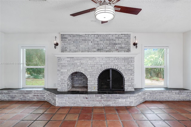 room details featuring ceiling fan, a fireplace, and a textured ceiling