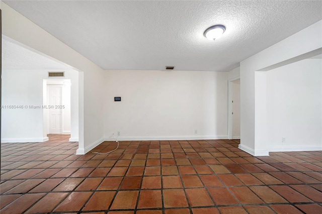 unfurnished room with a textured ceiling