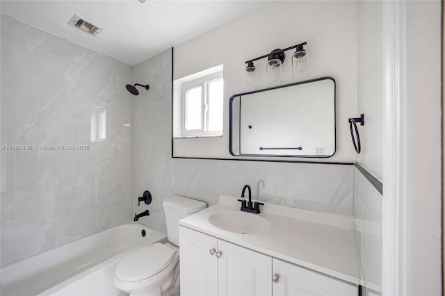 full bathroom featuring tiled shower / bath combo, toilet, tile walls, and vanity