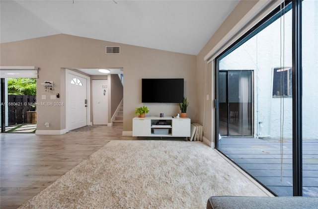 living room with vaulted ceiling and hardwood / wood-style flooring