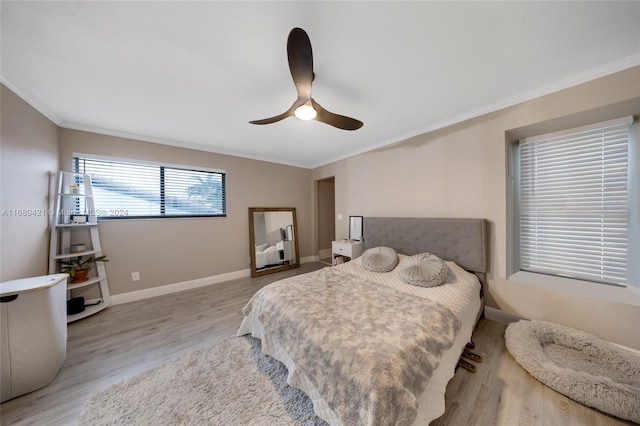 bedroom with crown molding, light hardwood / wood-style floors, and ceiling fan