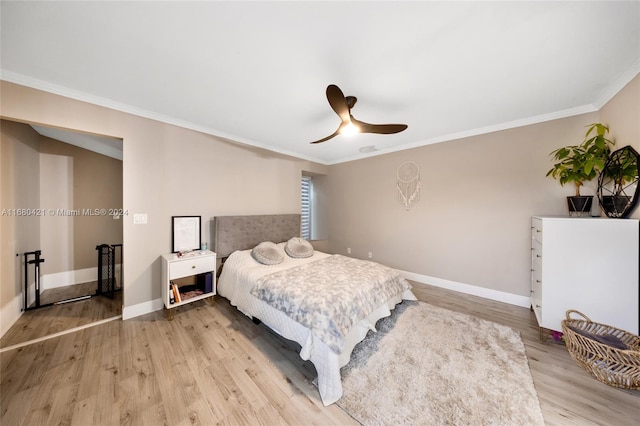 bedroom featuring ceiling fan, crown molding, and wood-type flooring