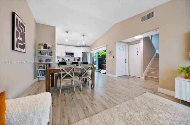 dining area featuring lofted ceiling and light hardwood / wood-style flooring