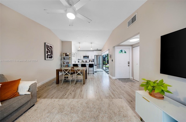 living room with lofted ceiling, light wood-type flooring, and ceiling fan