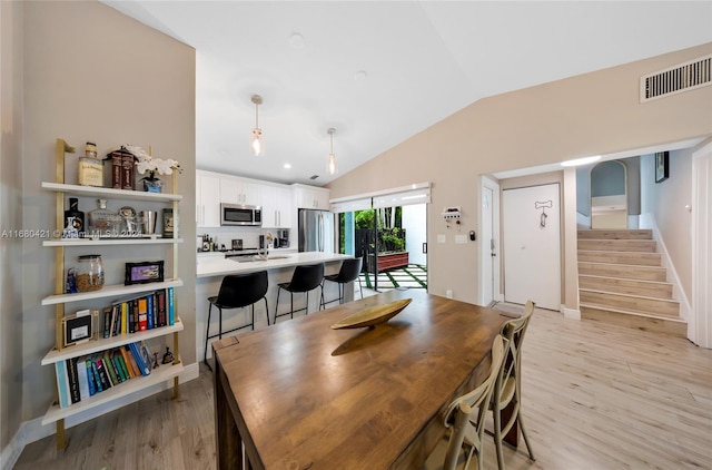 dining room featuring light hardwood / wood-style flooring and vaulted ceiling