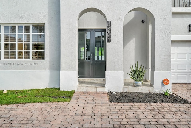 view of exterior entry featuring french doors and a garage