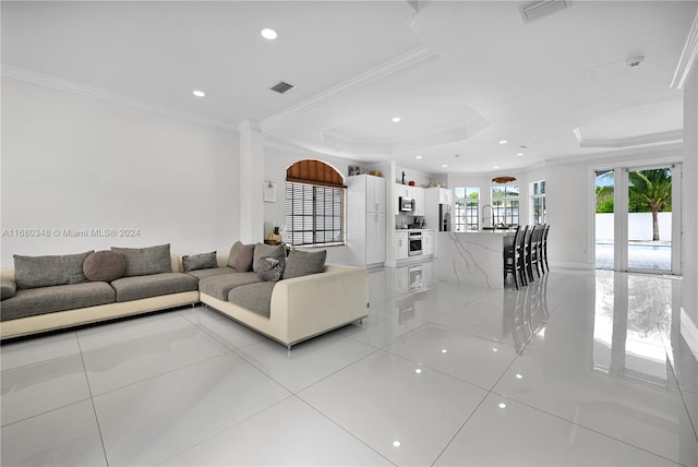 tiled living room featuring ornamental molding and a raised ceiling