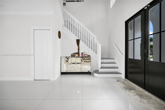 tiled entrance foyer with french doors and crown molding