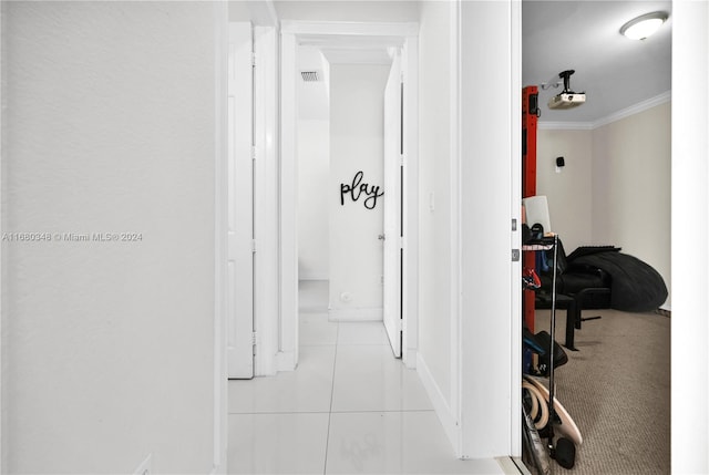 hall with ornamental molding and light tile patterned flooring