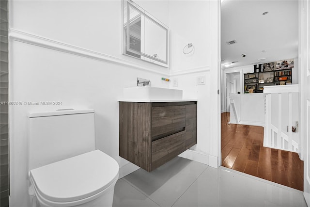 bathroom featuring vanity, toilet, and hardwood / wood-style flooring