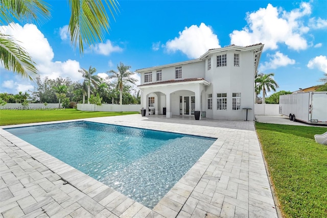 back of house with a yard, a patio, and a fenced in pool