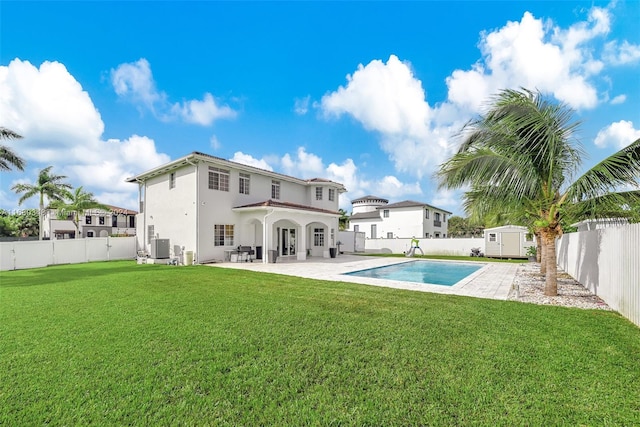 back of property featuring central AC unit, a lawn, a shed, a patio, and a fenced in pool